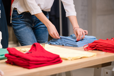Female fold blue clothes at clothing store.の写真素材