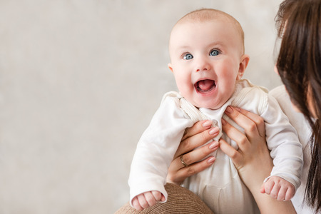Cute infant girl smile in mama handsの写真素材