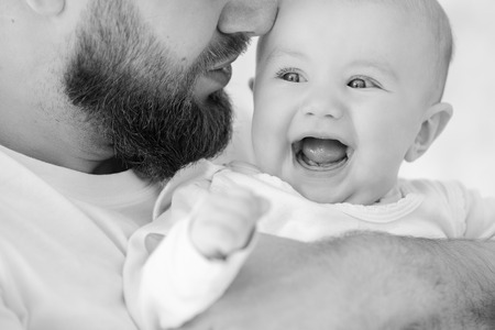 Happy baby girl in young father arms
