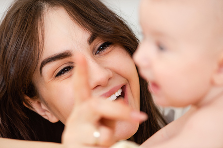 Smiling woman mom look at baby infantの写真素材