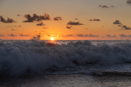 Seychelles coast with water spray at sunset light