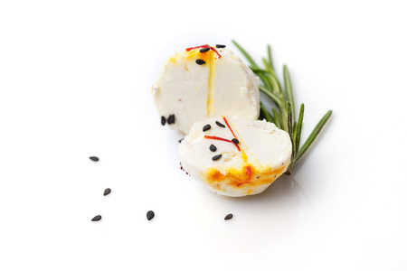 Two halves of cheese ball with sprig of thyme and sesame on white background.の写真素材