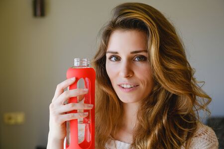 Portrait of beautiful sportive woman with bottleの写真素材