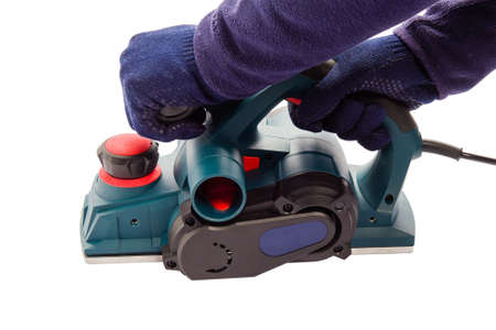 Male hand with an electric jointer plane. Male master hands wearing gloves on isolated white background.の写真素材