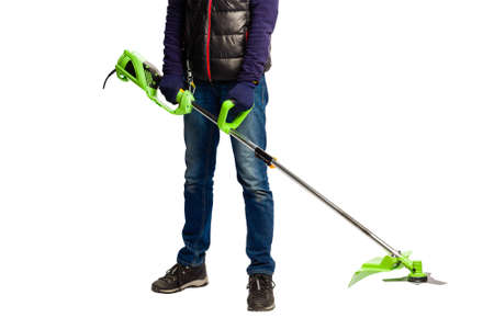 Male hands in gloves with lawn mower trimmer machine at isolated white studio background, gardening...