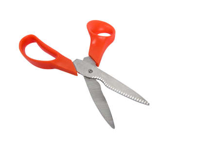 New open scissors with zigzag cloves on blade and orange handles at white isolated studio backgroundの写真素材