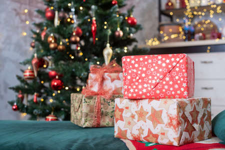 Decorated room with fir tree with red and golden ball ornaments, light garlands, gift boxes for Christmas and New year holidaysの写真素材