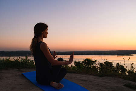 Silhouette of woman meditate on sport matの写真素材