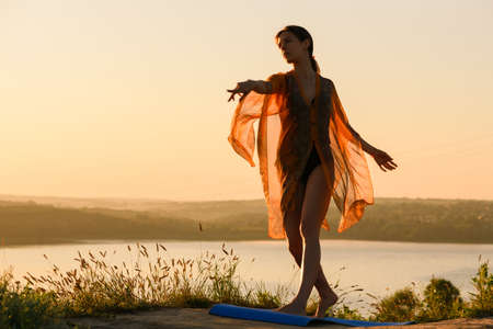 Woman dance on hill at sun lightの写真素材