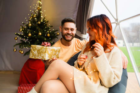 Young couple are sitting in a cozy geo dome tentsの写真素材