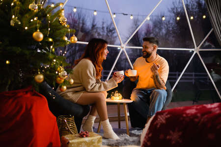 Couple talking and drinking tea from large cups.の写真素材