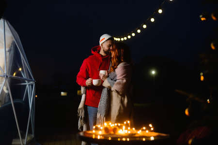A loving couple with cups hugging on the terraceの写真素材