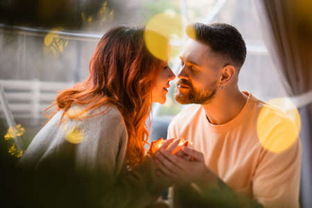 A loving couple holds a magical light in their hand. Couple about to kiss. Warm light illuminates the face of the man and woman.の写真素材