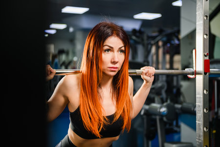 Sportive fit strong woman exercise with lifting weights, hold heavy dumbbells at modern gym interior, healthy lifestyleの写真素材