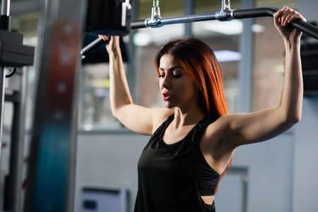 Woman during hand training exercise in gym, attractive female portrait at workout process in gym...