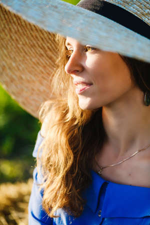Close up of adorable young woman in wide brim hat, countryside romantic fashion.の写真素材