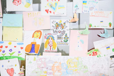 Dnipro, Ukraine - April 04, 2022: Many children's drawings about the war in Ukraine. A wall of children's messages about peace in Ukraine. Refugee Assistance Center in Dnipro.のeditorial素材
