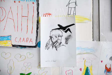 Dnipro, Ukraine - April 04, 2022: Many children's drawings about the war in Ukraine. A wall of children's messages about peace in Ukraine. Refugee Assistance Center in Dnipro.のeditorial素材