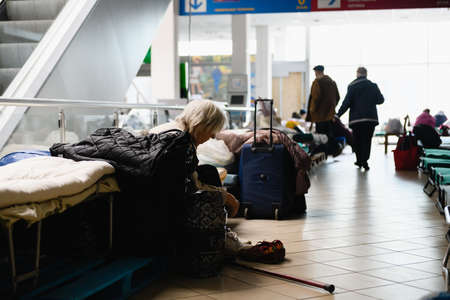 Dnipro, Ukraine - April 04, 2022: An elderly disabled woman sits on a bed in a shopping center converted for refugees in Dnipro.のeditorial素材