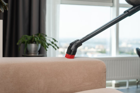 Sofa cleaning with vacuum cleaner. Home cleaning background. Dust cleaning in the house.の写真素材