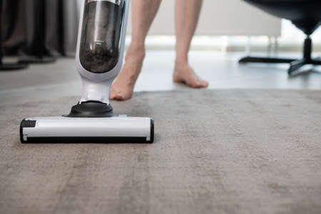 Home cleaning in the apartment with a vacuum cleaner. Carpet cleaning with a vacuum cleaner.