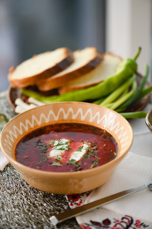 Traditional Ukrainian borscht. Clay Bowl of red beet root soup borsch with white cream.の写真素材