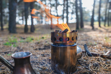 Portable wood stove in the forest. Making coffee process on campfire.の写真素材