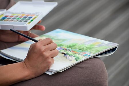 Painter draw watercolor picture on the streetの写真素材