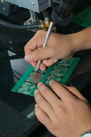 hands of the Chinese worker engraves plate for microchips in the factory.