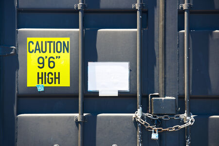 Locked container door with chain and cautionの写真素材