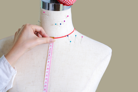 Tailors dummy and hand with ruler make measurementの写真素材