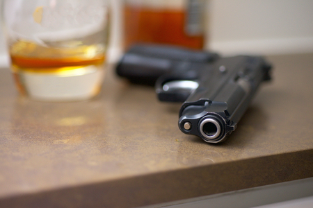 The gun with glass and cognac on the marble table