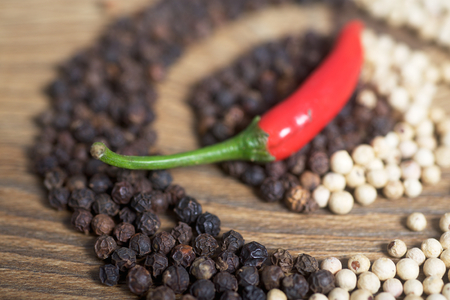 Red chilly peppers with black and white peppers backgroundの写真素材