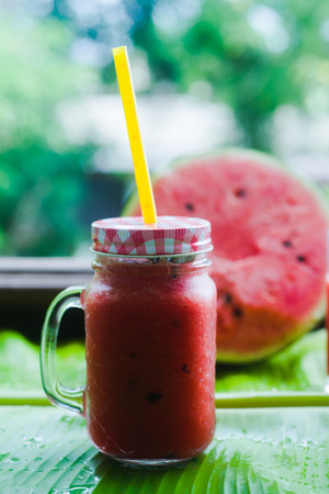 Watermelon juice and mint leaf in a cup of glass with a straw, macro photoの写真素材