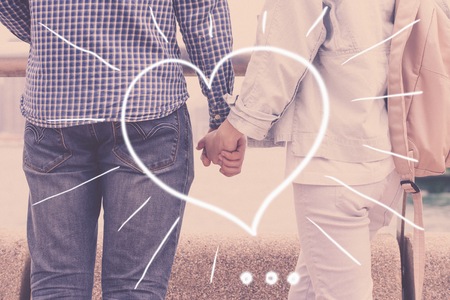 Guy and pretty girl in love, hands holding together and drawing valentine signの写真素材