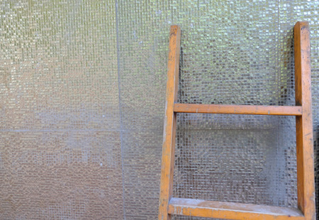 Stepladder stay near textured wall background photo