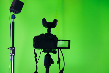 Video camera on a tripod and microphone on a green background. The chroma key. Green screen.の写真素材