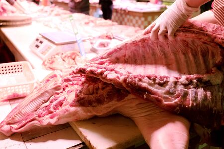 Butcher s hands cutting pork meat into pieces for a meat market in China