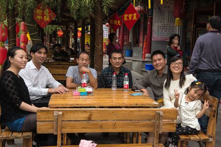 CHONGQING, SICHUAN, CHINA - OCTOBER 26 2013: Modern Chinese family on a walk in anticipation of lunch in a small provincial townのeditorial素材