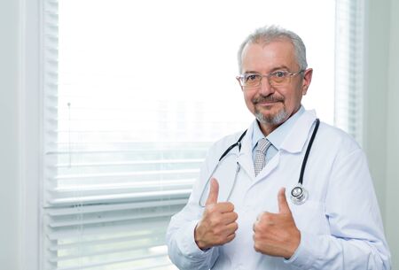 Doctor showing thumbs up satisfaction signの写真素材