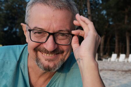 Mature man with glasses smiling looking at the camera