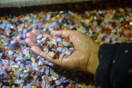 Many kinds of gems in womans hands