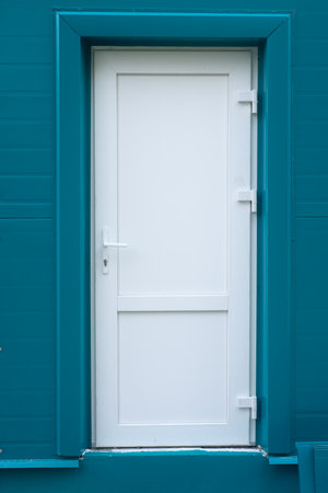 White metal door in a dark blue wall
