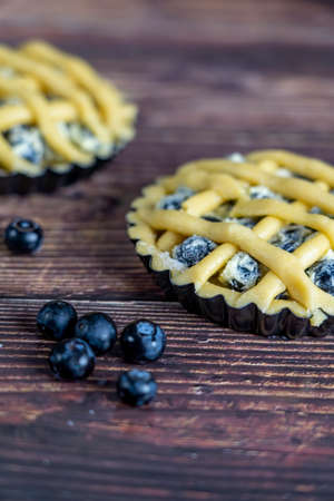 Small cups of delicious blue berry tart or pie  on wood table background.の写真素材