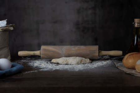 Dough and dough roller on a wooden surface.の写真素材