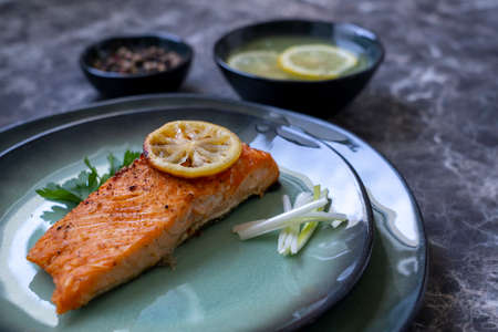 Row Salmon fish fillet uncooked with different spices and lemon slice served on plate.の写真素材
