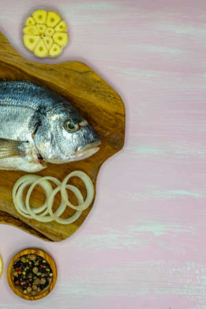 Mahi-mahi or widely called dorado fish row, top view.on wood cutting board and a wooden pink table.の写真素材