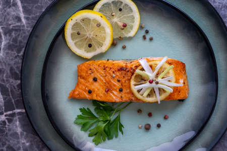 Side view of Salmon fish fillet cooked with different spices and served on plate.の写真素材