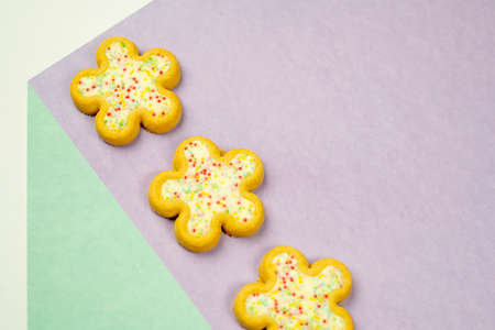 Easter flower biscuits on flat colored background .Easter holiday candy concept.の写真素材
