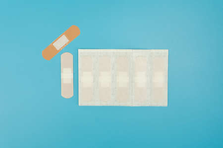 First aid sore plaster blue colored surface.の写真素材